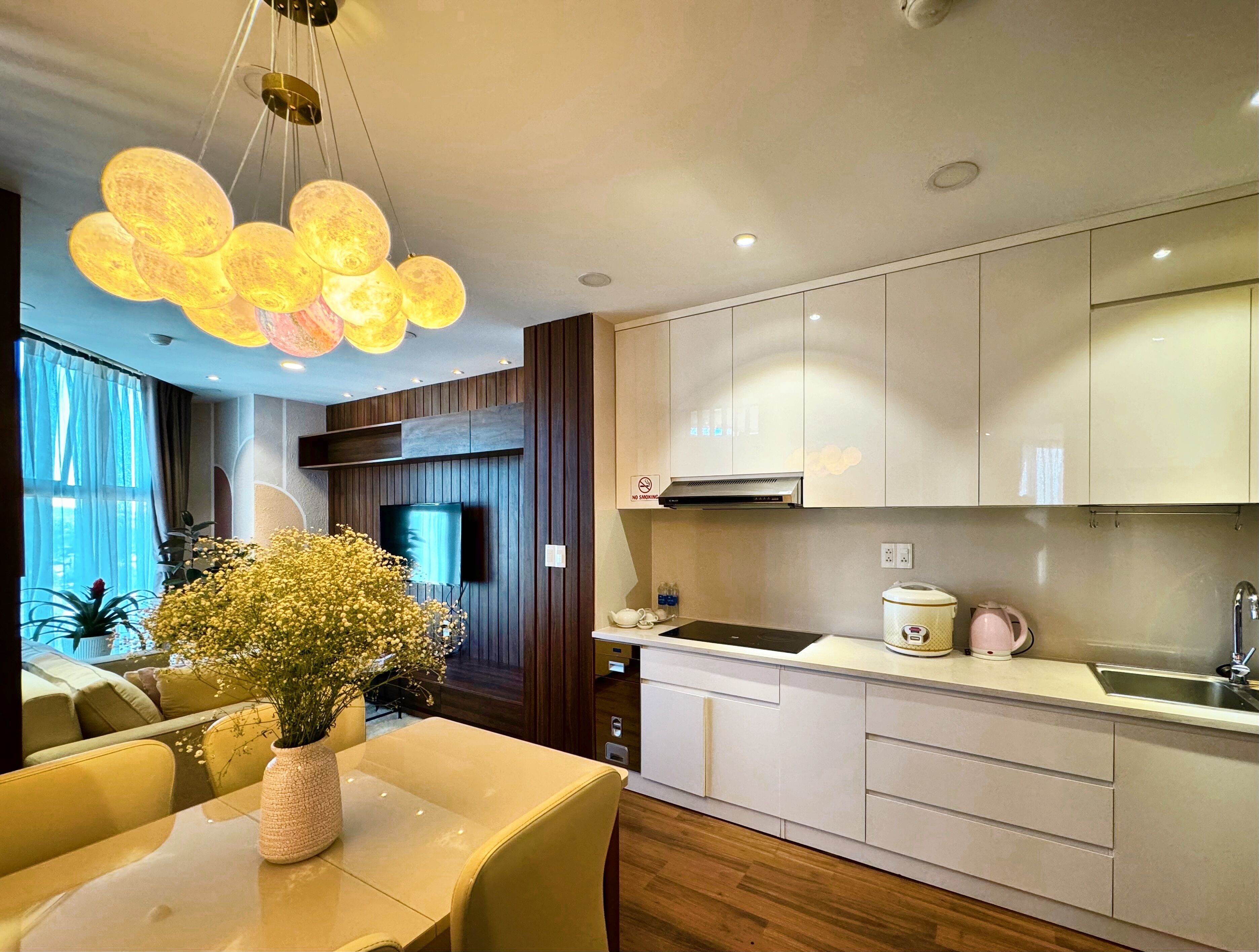 A modern kitchen with a dining area, wooden paneling, and a large window.