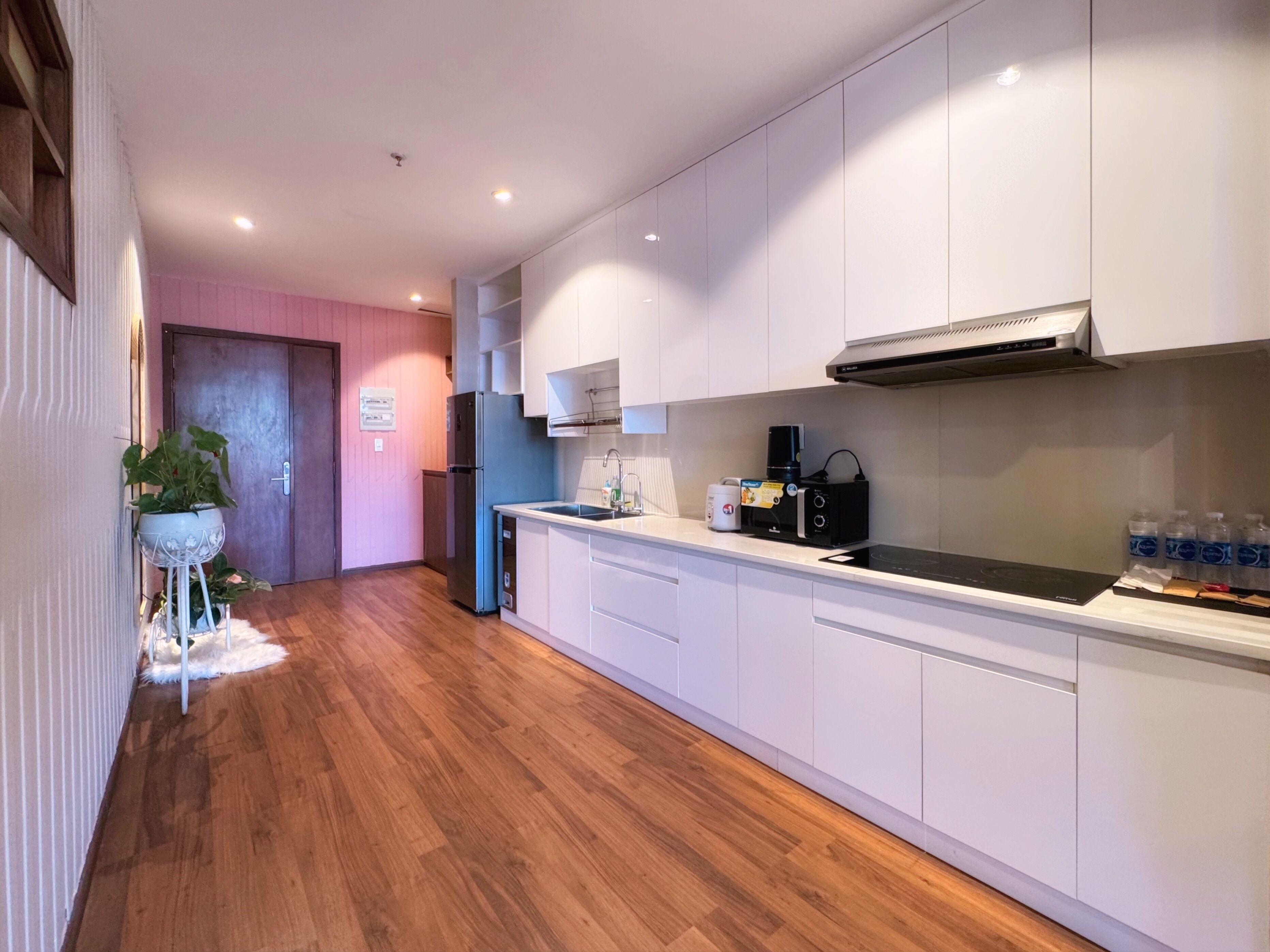 A modern kitchen with white cabinets, a black countertop, and a built-in stove.