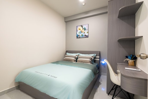 A modern bedroom with a bed, a desk, and a chair.