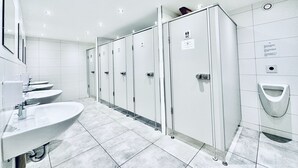 A modern restroom with multiple sinks, individual lockers, and urinals. - ZIMMERzuVERMIETEN.ch Oensingen (Oensingen)
