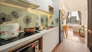 A modern kitchen with white cabinets, a built-in oven, and a stove. - SaiGon Rivergate (Ho Chi Minh City)