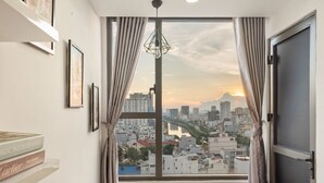 A room with a large window, a view of a cityscape, and a door. - SaiGon Rivergate (Ho Chi Minh City)