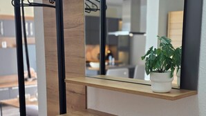 A modern vanity with a wooden countertop, a mirror, and a black metal hanger rack. - Apartment 6 "Petra" (Sankt Andreasberg)