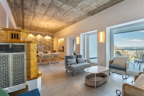 Een ruime woonkamer met balkon, eethoek en keuken.