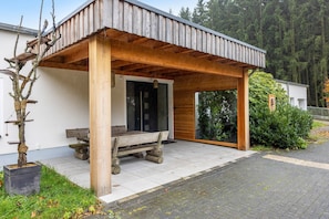 Una estructura de madera con un banco, una puerta y una ventana.