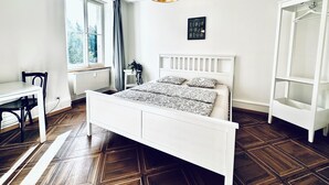 A bedroom with a white bed, a desk, and a wardrobe. - Business Apartment Derendingen (Derendingen)
