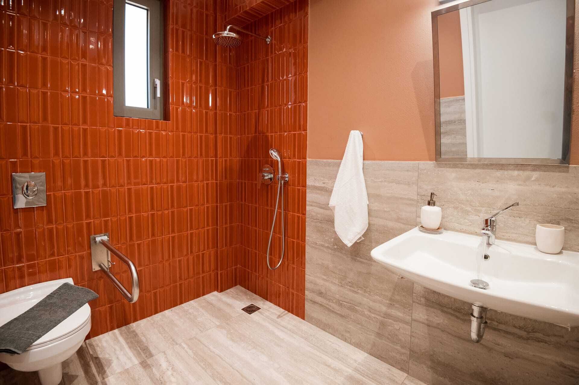 Een badkamer met een douche, toilet en wastafel.