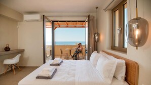Une chambre d’hôtel avec un lit, une chaise, une table et une vue sur la mer.