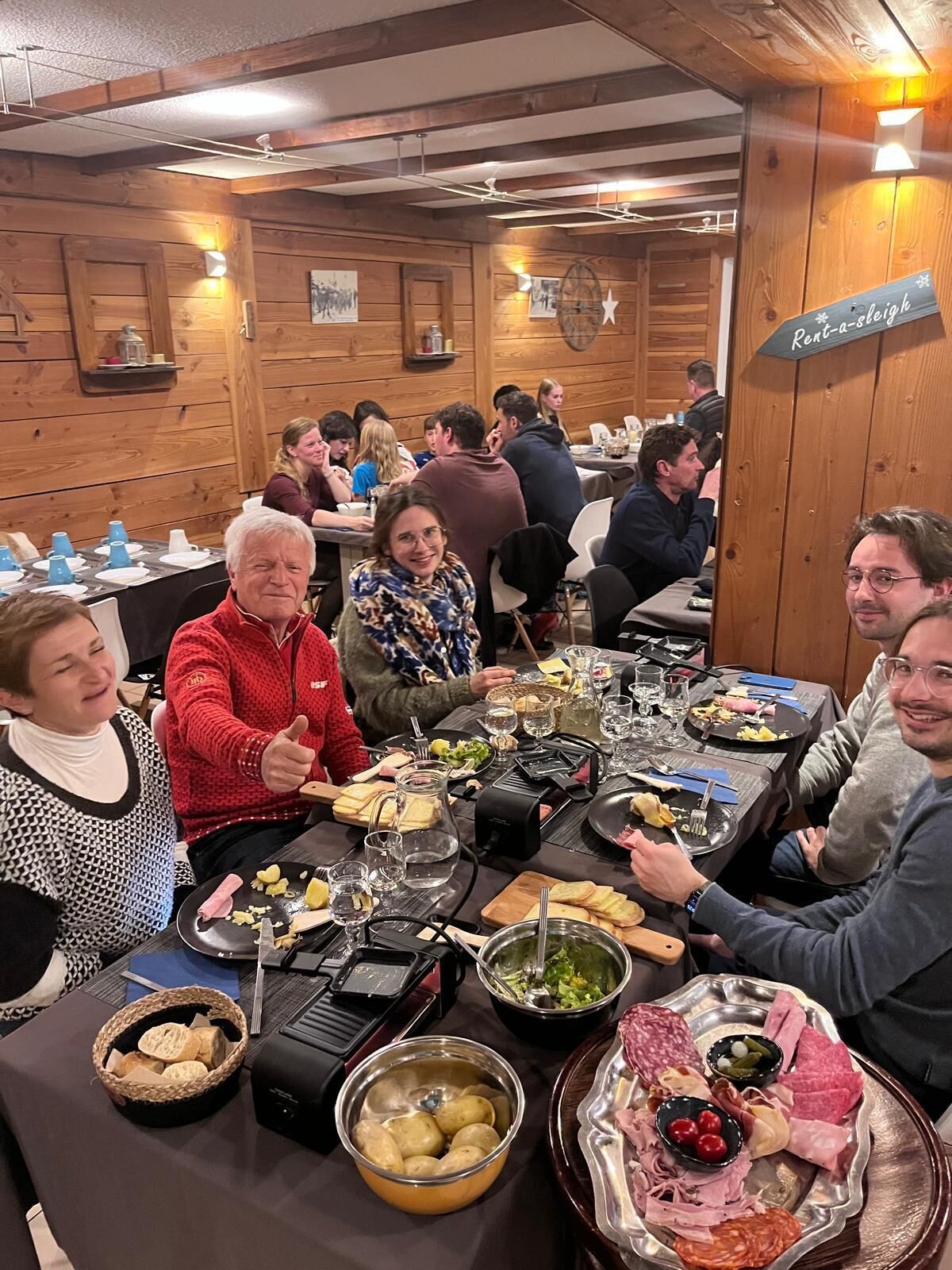 A restaurant with wooden walls and tables set for a meal.