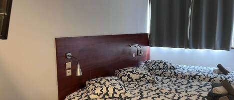 Una habitación de hotel con una cama, un escritorio y una silla.