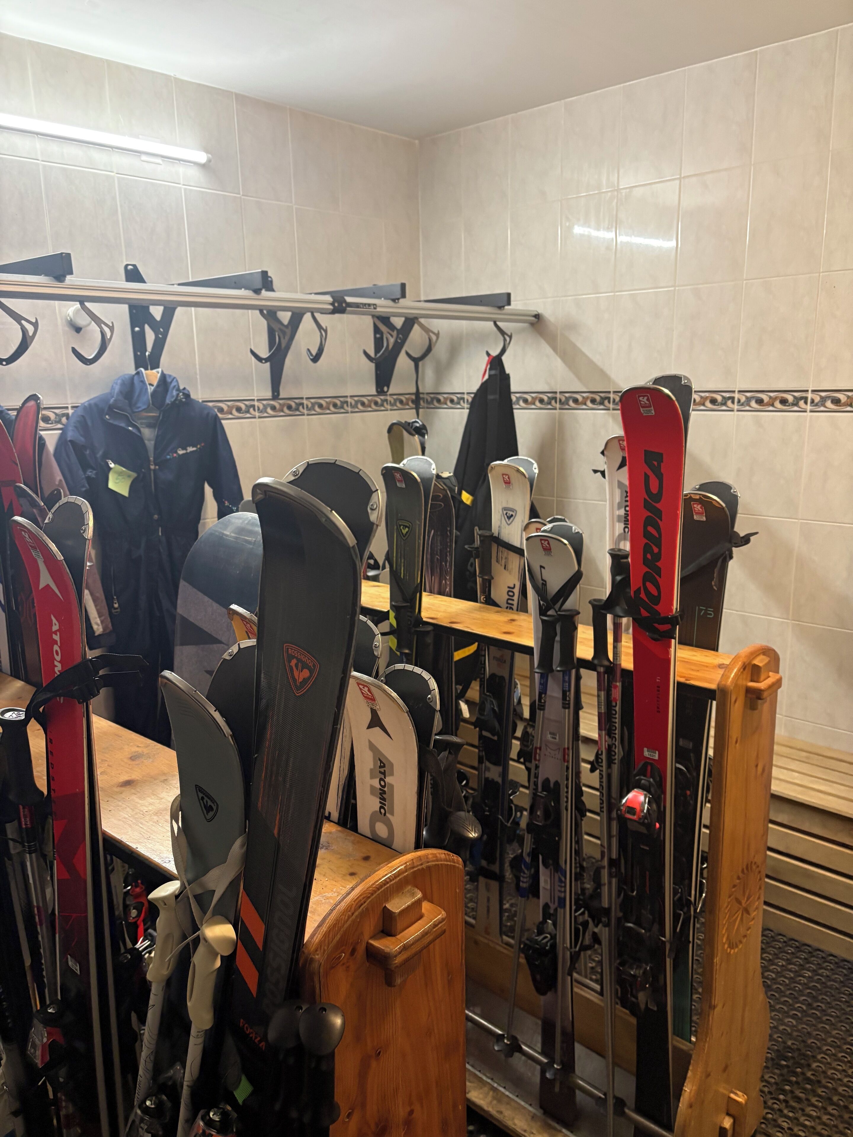 A ski storage area with skis and ski poles organized on racks and shelves.
