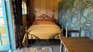 Une pièce chaleureuse avec un lit, une table en bois et un mur orné de motifs.