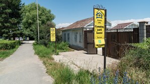 A yard hostel with a rustic building, a paved path, and surrounding greenery. - Camping Yard Hostel Karakol (Karakol)