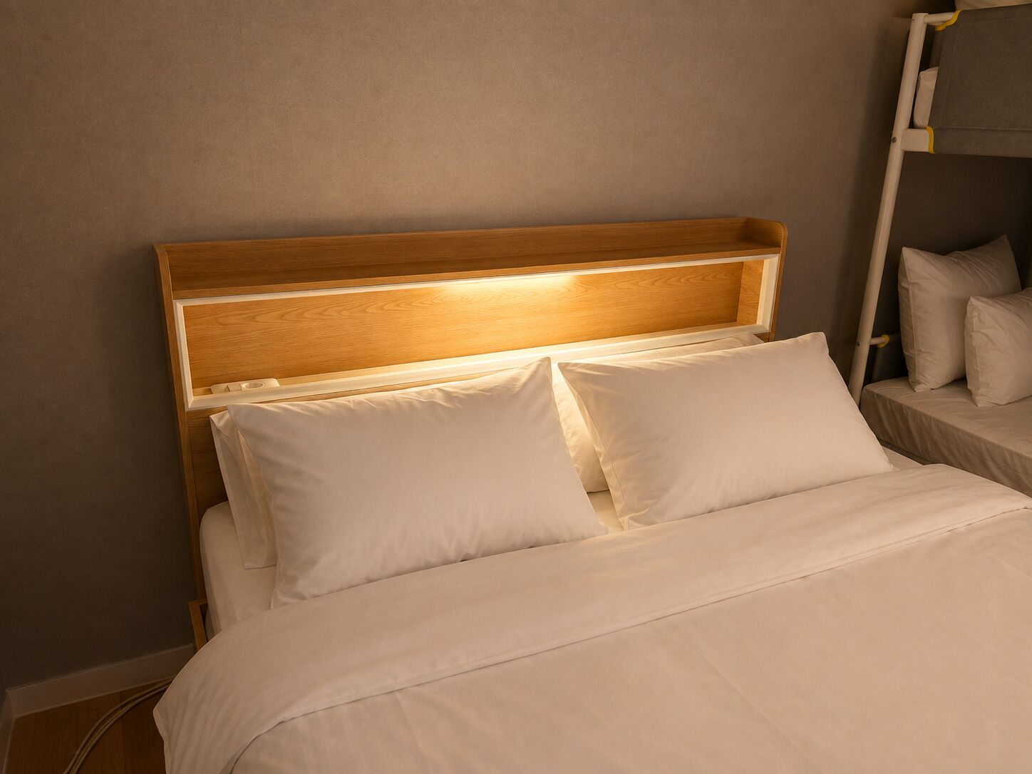 A bed with a wooden headboard and white bedding.