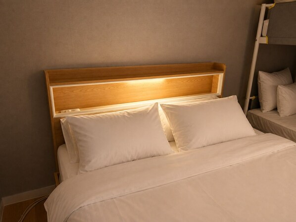 A bed with a wooden headboard and white bedding.
