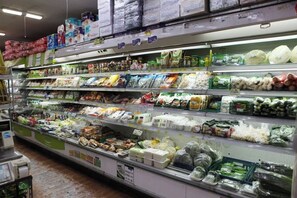 Un rayon de supermarché où sont exposés divers produits emballés et des produits frais.