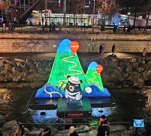 Een waterpartij met een beerbeeld, een bord waarop 'TAIWAN WAVE WONDER' staat, en een rotsachtig landschap.