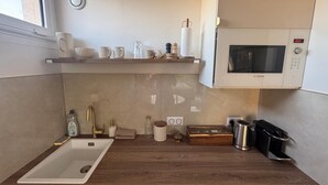 A modern kitchen with a Bosch microwave, a sink, and a wooden countertop. - Upscale studio with balcony-La Défense (Nanterre)