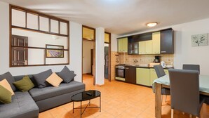 Un apartamento moderno con sala de estar, mesa de comedor y cocina.