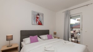 A hotel room with a bed, two bedside tables, a painting, and a view of the outside. - Villa Bilanžic - Omiš by Villas Guide (Kreševo)