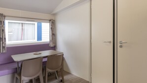 A room with a window, a table, two chairs, and a door.