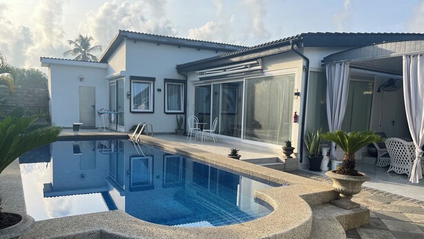 A modern house with a swimming pool, outdoor furniture, and potted plants. - Petit Hambourg guest house by the pool (Baguida)