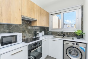 Apartamento, vista para a cidade | Cozinha privada | Geladeira grande, micro-ondas, fogão, cooktop