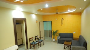 A living room with a sofa, chairs, a small table, and a potted plant. - Hotel Shri Bhaskar (Bareilly)