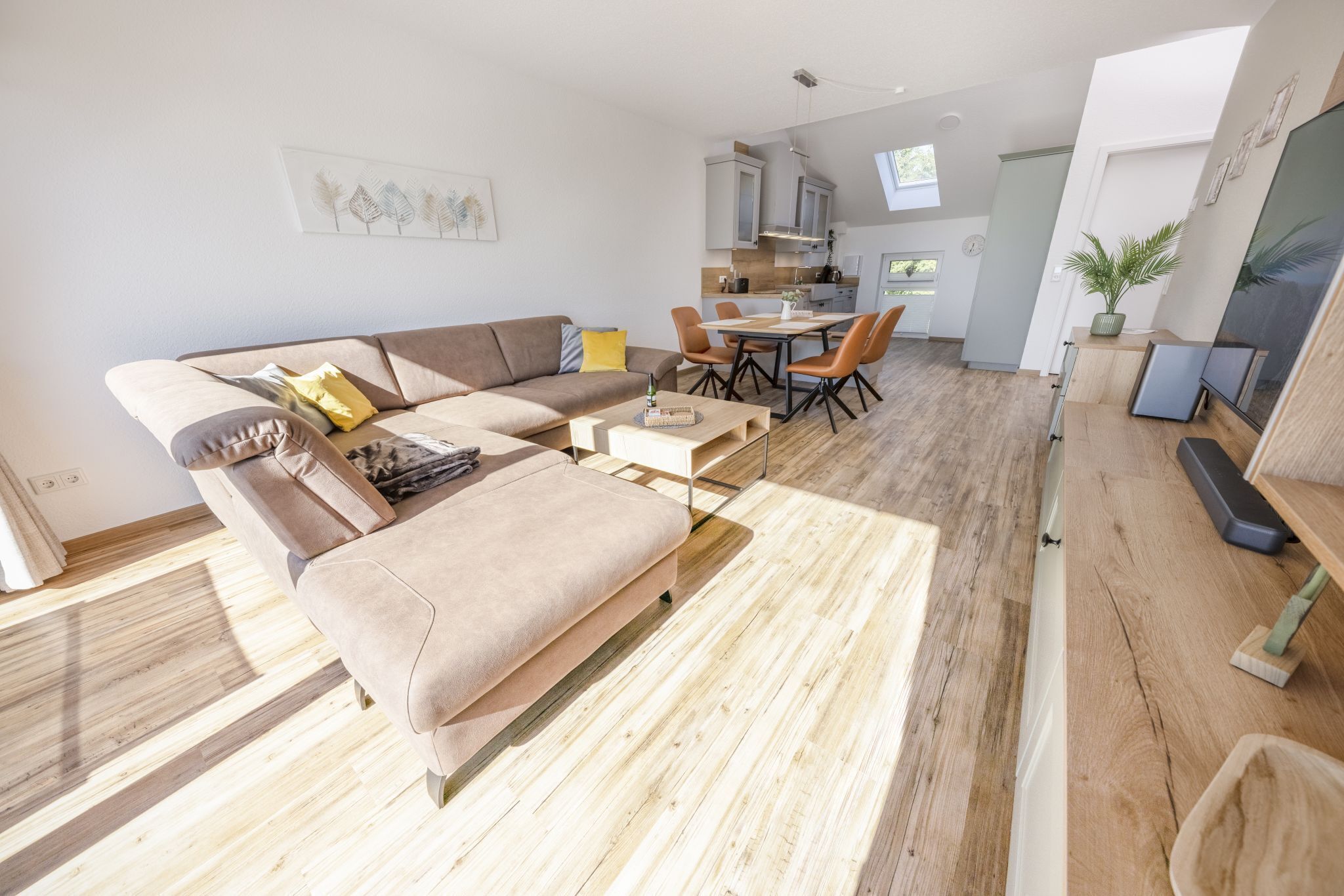 En moderne stue med sofa, sofabord og spiseområde.