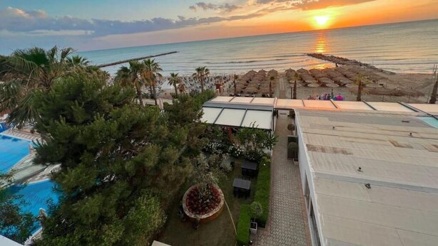 A resort with a pool, outdoor seating, and a sunset view. - Okej Hotel (Golem)