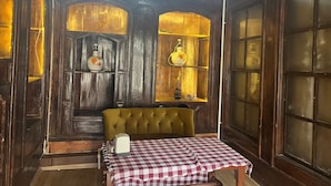 Een kamer met een tafel met ruitdessin, een gestoffeerd hoofdbord en houten lambrisering.
