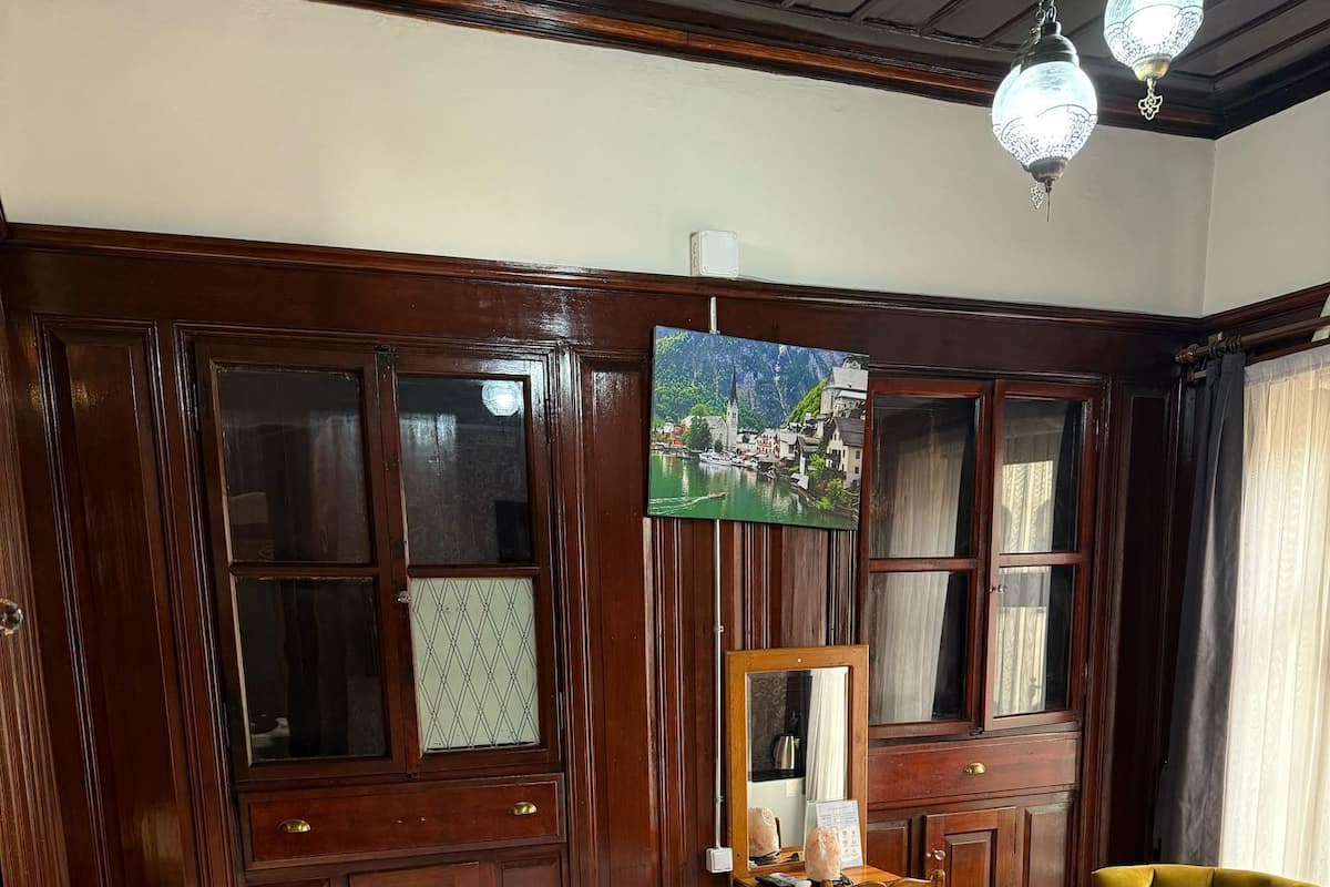 Un dormitorio con cama de madera, cómoda de madera, una silla y un cuadro en la pared.