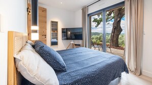 A bedroom with a bed, a TV, a large window, and a view of the outdoors. - CALIFORNIAN VILLA IN GATED COMMUNITY (OPIO)