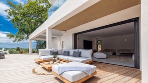 An outdoor living area with a sofa set, a wooden coffee table, and a woven rug. - CALIFORNIAN VILLA IN GATED COMMUNITY (OPIO)
