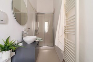 Chuveiro, secador de cabelo, toalhas de banho, shampoo