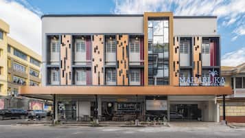 Um edifício moderno com uma placa indicando 'MAHARIKA City Inn Bacolod'.