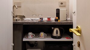 Una cuina compacta amb rentatge, cafetera i armaris d'emmagatzematge.