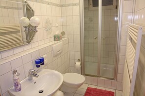 Une salle de bain avec un lavabo, des toilettes et une douche.