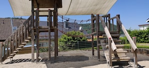 A playground with wooden structures, including a rope net and a slide. - Apartment 'Talblickappartement - Apt 2' with Shared Terrace, Garden and Wi-Fi (Seelbach)