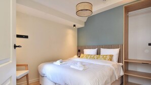 Un dormitorio ordenado con cama, mesitas de noche y armario.