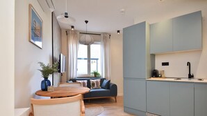 Una cocina moderna con armarios azules, una mesa de comedor de madera y un sofá azul.
