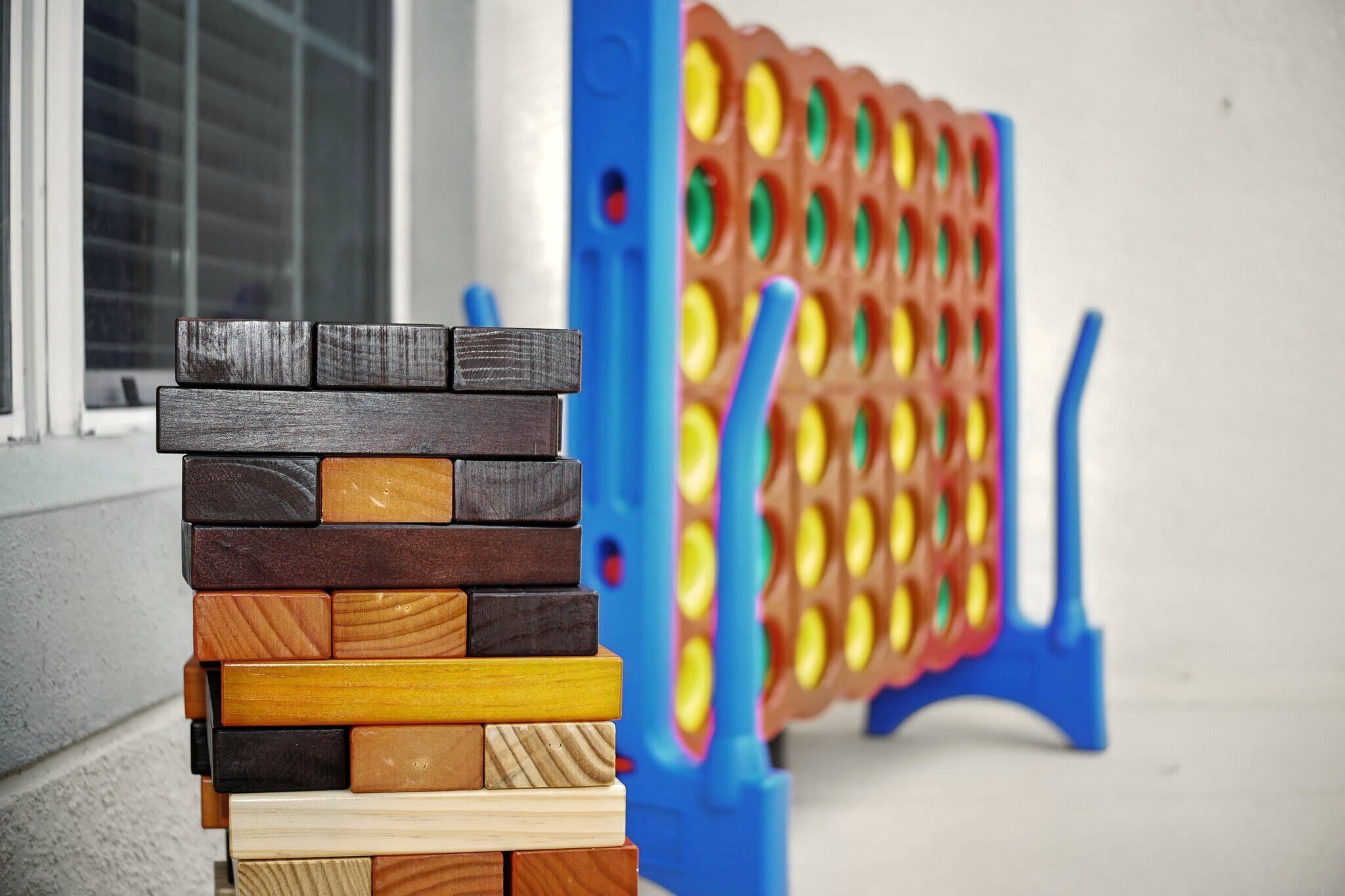 A stack of wooden blocks in front of a colorful toy structure.