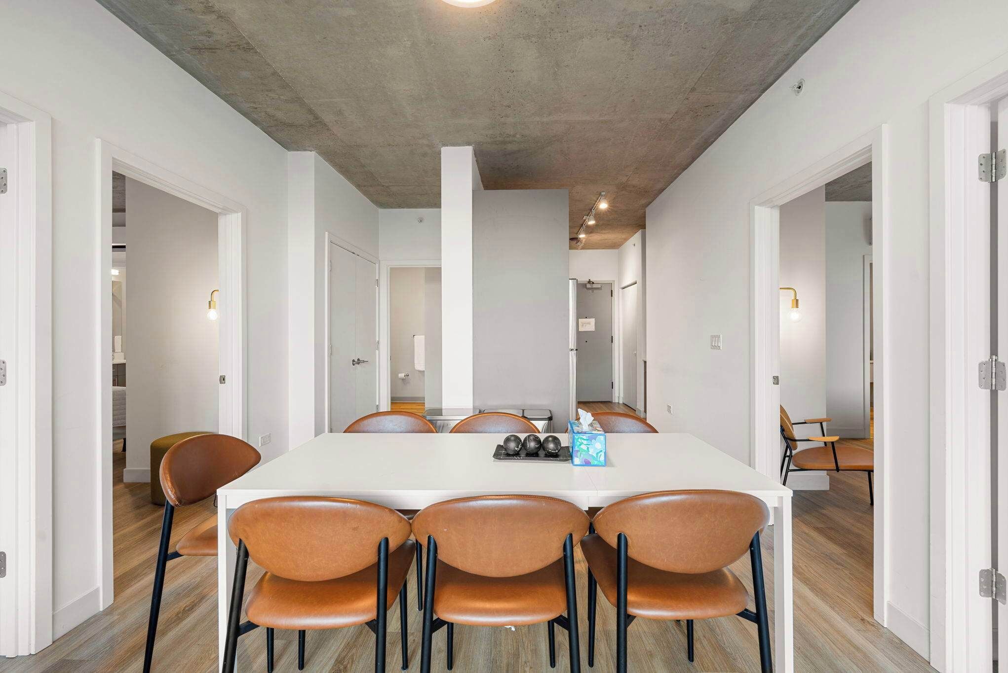 A conference room with a long table, six chairs, and a whiteboard.