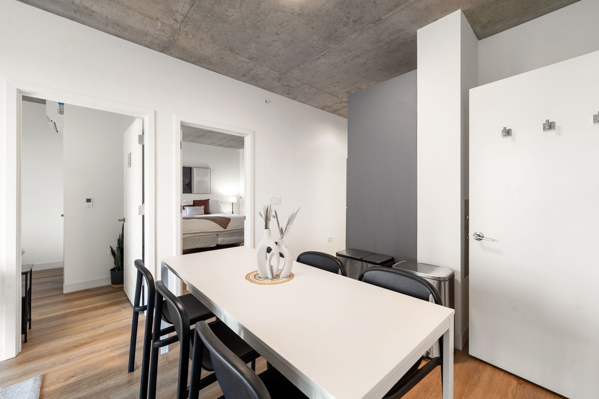 Un comedor moderno con una mesa larga, sillas y un jarrón con adornos decorativos.