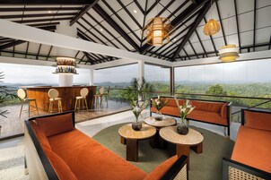 A modern lounge area with a bar, seating, and a view of the mountains.