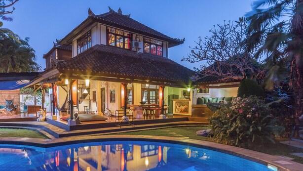 A traditional building with a swimming pool in front.