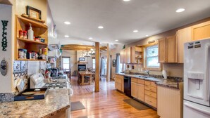 A spacious kitchen with wooden cabinets, granite countertops, and a central island. - Mountain Meadow Lodge • Dog-Friendly • Hot Tub (Frisco)
