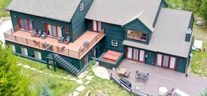 A large, two-story house with a deck and outdoor seating area. - Mountain Meadow Lodge • Dog-Friendly • Hot Tub (Frisco)