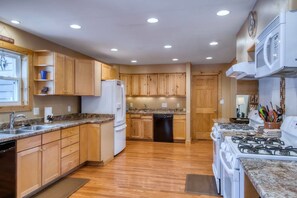 A kitchen with wooden cabinets, a refrigerator, a dishwasher, and a stove. - Mountain Meadow Lodge • Dog-Friendly • Hot Tub (Frisco)