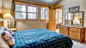 A bedroom with a large bed, a dresser, a mirror, and two windows. - Mountain Meadow Lodge • Dog-Friendly • Hot Tub (Frisco)